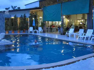 a man in a swimming pool at a hotel at Forest Bungalows & Mama's Restaurant in Chalong