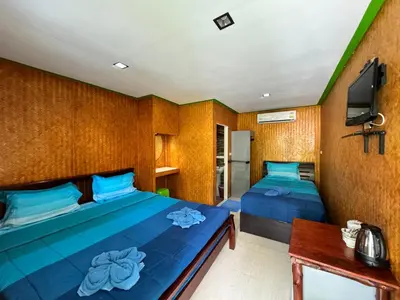 a bedroom with two beds and a desk and a tv at View Garden Resort in Phi Phi Don