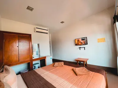 a bedroom with a bed and a wooden cabinet at View Garden Resort in Phi Phi Don