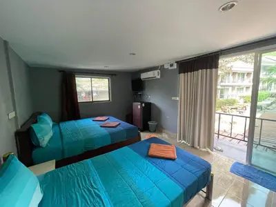 a hotel room with two beds and a balcony at View Garden Resort in Phi Phi Don