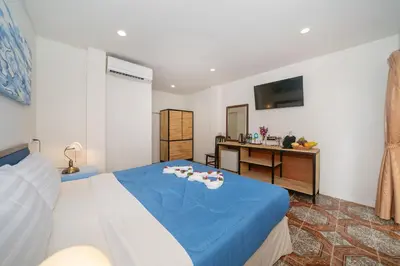 a bedroom with a blue bed and a desk at Oceanview Bungalows by EAT in Karon Beach