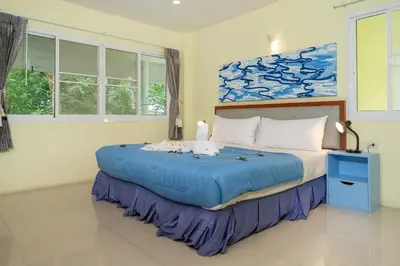 a bedroom with a large blue bed in a room at Oceanview Bungalows by EAT in Karon Beach