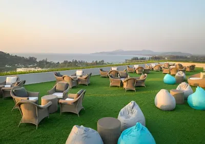 a group of chairs sitting on the grass on a balcony at Уютные апартаменты в Mide Grant in Phuket Town