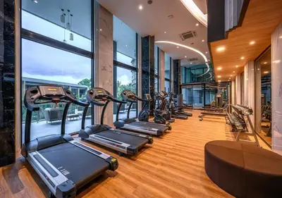 a row of treadmills in a gym with windows at Уютные апартаменты в Mide Grant in Phuket Town