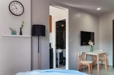 a bedroom with a table and a clock on the wall at Great Hill Jungle View Pool Gym Naiyang in Nai Yang Beach