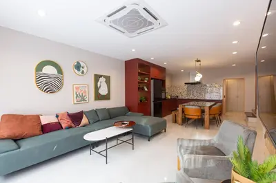 a living room with a green couch and a dining room at Cozy Patong Beach House 3 Bedrooms in Patong Beach