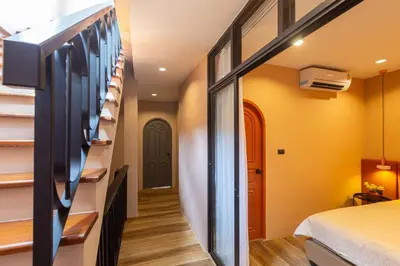 a room with a bed and a hallway with stairs at Cozy Patong Beach House 3 Bedrooms in Patong Beach