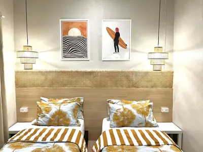two beds in a room with pictures of a surfer at Surfer House Patong Center 3 Bedrooms in Patong Beach