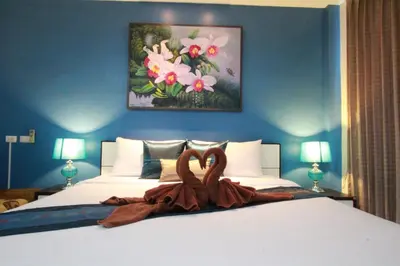 a bedroom with a bed with two swans on it at Sleep Easy in Kata Beach