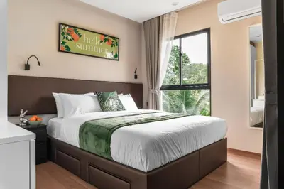 a bedroom with a large bed and a window at Title V Pool View 3fl Gym Hammam Rawai in Rawai Beach