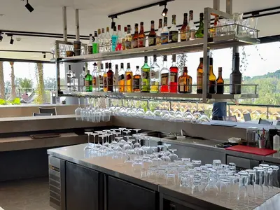 a bar with many glasses on a counter with drinks at Kamala Beach D76 Exclusive Junior Suite in Kamala Beach