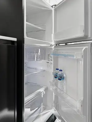 an open refrigerator with bottles of water in it at Great Hill Cozy Stay Pool Gym Naiyang in Phuket Town
