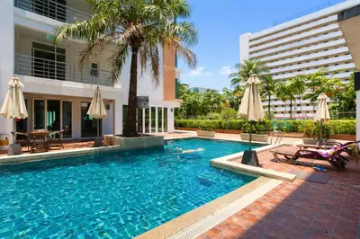 a swimming pool with umbrellas next to a building at Haven Lagoon Condominium in Patong Beach