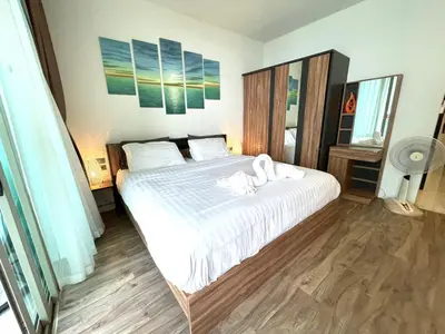 a bedroom with a large bed with towels on it at Oceana Resort Kamala Ocean View 5th floor in Kamala Beach