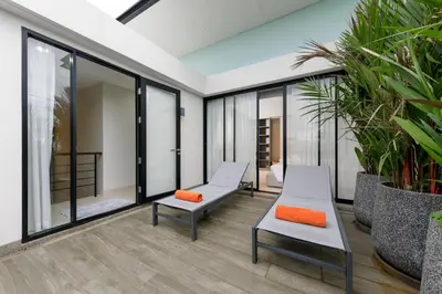 two benches in a room with plants at Modern villa with pool close to the beach - LP #97 in Phuket Town