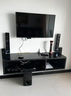 a black entertainment center with a flat screen tv and speakers at Luxurious 3BR Penthouse Jacuzzi Seaview in Kamala Beach