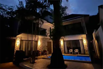 a house with a tree in front of it at night at Exquisite 3BR Private Pool Villa: Prime Location in Kamala Beach