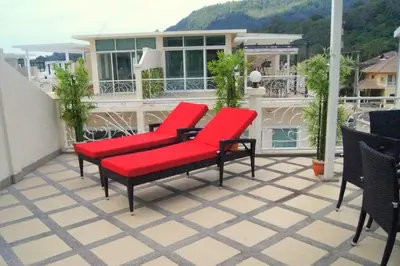 two red chairs sitting on top of a balcony at Stunning 4-BR House with Inviting Swimming Pool in Kamala Beach