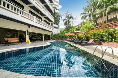a swimming pool next to a building with a resort at Patong Central Residence & Apartment in Patong Beach