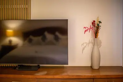 a television sitting on a table with a vase of flowers at Phuket Boutique Pool Villa-79 in Rawai Beach