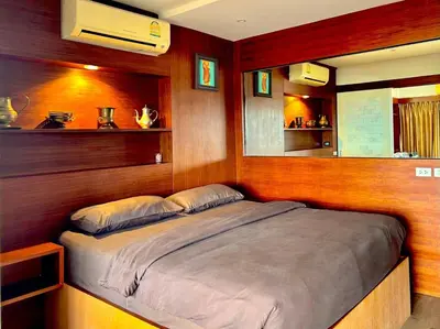 a bed in a room with wood paneling at Patong Tower Holiday Rentals in Patong Beach
