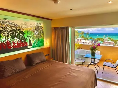 a bedroom with a bed and a view of the ocean at Patong Tower Holiday Rentals in Patong Beach