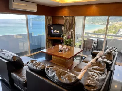 a living room with couches and a table and a television at Patong Tower Holiday Rentals in Patong Beach