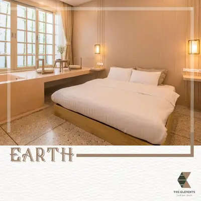 a bedroom with a bed and a desk and a tub at The Elements Boutique House in Phuket Town