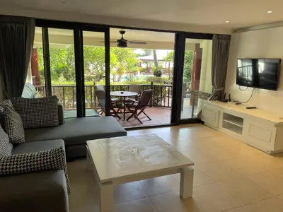 a living room with a couch and a tv and a table at Peaceful retreat at Kalim Bay - pool bar garden in Patong Beach