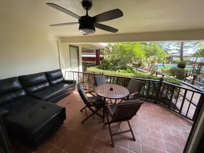 a living room with a couch and a table and chairs at Peaceful retreat at Kalim Bay - pool bar garden in Patong Beach