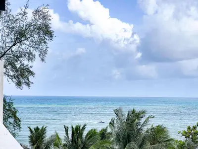 a view of the ocean from a beach with palm trees at 88 House Patong in Patong Beach