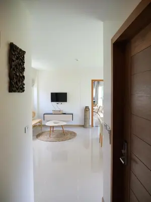 a white living room with a tv and a door at Karon beach apartment & sea view pool in Karon Beach