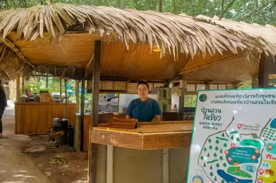 a man standing at a counter in a food stand at Greenheart Garden View Camp Phuket in Kata Beach