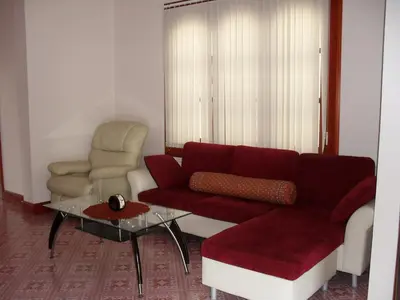 a living room with a red couch and a chair at Majestic Villas Phuket in Rawai Beach