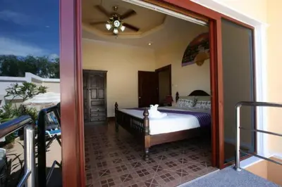 a bedroom with a bed and a mirror at Majestic Villas Phuket in Rawai Beach