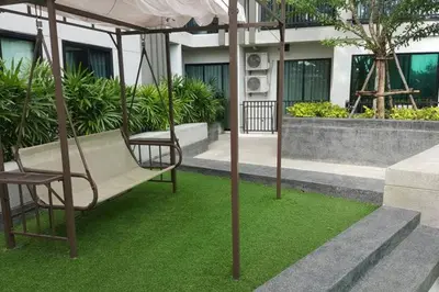 a swing in a garden with green grass at At Laguna at Zcape Condo in Bang Tao Beach