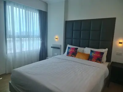 a bedroom with a large bed and a large window at At Laguna at Zcape Condo in Bang Tao Beach