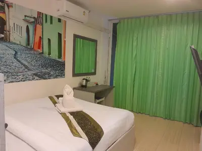 a room with a bed with a green curtain at Toto Residence in Ao Nang Beach