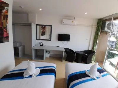 a hotel room with two beds and a desk at Toto Residence in Ao Nang Beach