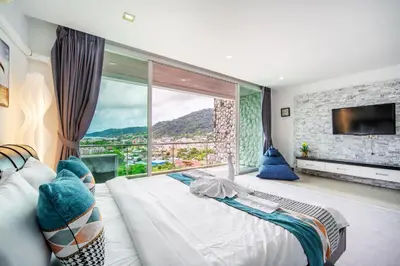 a bedroom with a bed and a large window at Patong Villa1\u4e09\u5367\u6cf3\u6c60\u522b\u5885\u4e24\u4e2a\u6d77\u666f\u623f \u8fd1\u73ed\u8d5e\u6c5f\u897f\u51b7\u6d77\u6ee9\u4e2d\u6587\u7ba1\u5bb6 in Patong Beach