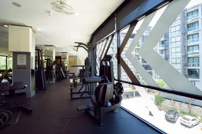 a gym with tread machines and a large window at Modern Tropical Kamala Beach in Phuket Town