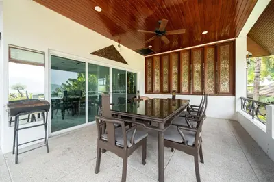 a dining room with a glass table and chairs at Kinnaree Grand Villa - pool, panoramic views, maid in Kamala Beach