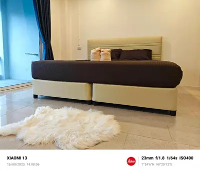 a bed with a white rug on the floor with a bed at AB House in Kathu