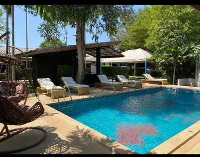 a large swimming pool with lounge chairs at Apollo Hotel Chalong in Ban Suan