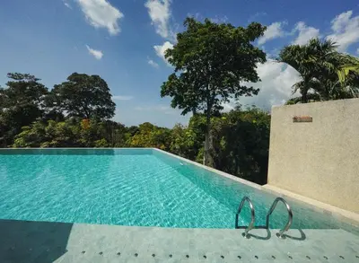 a swimming pool with two flip flops sitting next to it at Bluepoint SeaView Retreat Patong in Patong Beach