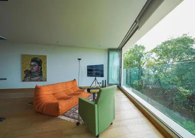 a living room with an orange couch and a large window at Bluepoint SeaView Retreat Patong in Patong Beach