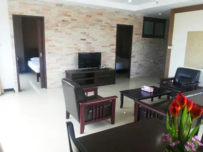 a living room with two chairs and a television at Patong Tower by United 21 Thailand in Patong Beach