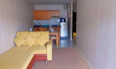a living room with a couch and a kitchen at Patong Tower by United 21 Thailand in Patong Beach