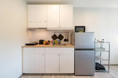 a kitchen with white cabinets and a refrigerator at The Title Residencies Nai Yang - 1 Bedroom Apartment in Nai Yang Beach