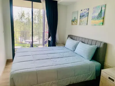 a bedroom with a large bed and a balcony at Apartments in Skypark Laguna Bang Tao in Bang Tao Beach